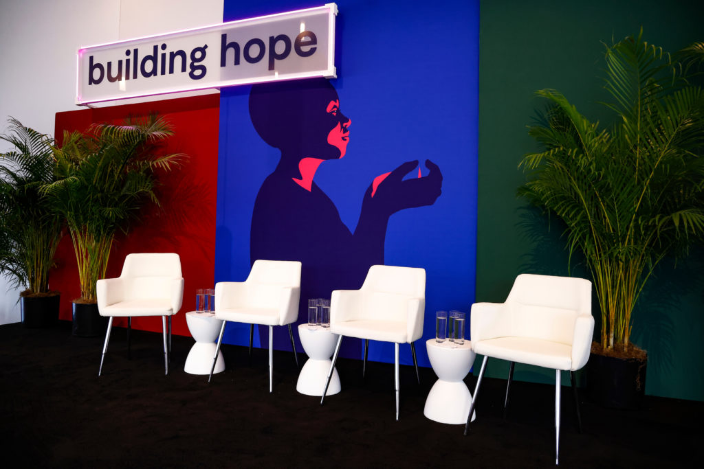Image from Building Hope Mental Health Strategy Summit, hosted by Inseparable on November 16, 2022. Stage at event with 4 chairs and sign that says "building hope".