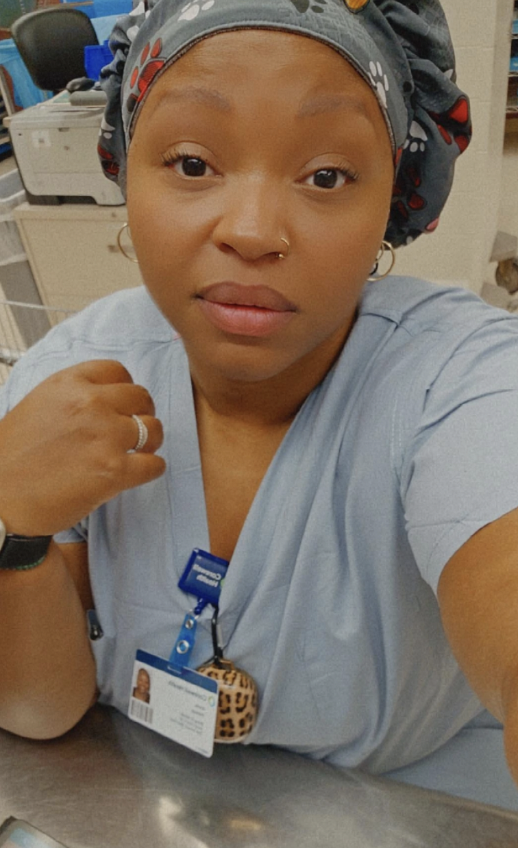 A woman wearing scrubs taking selfie.